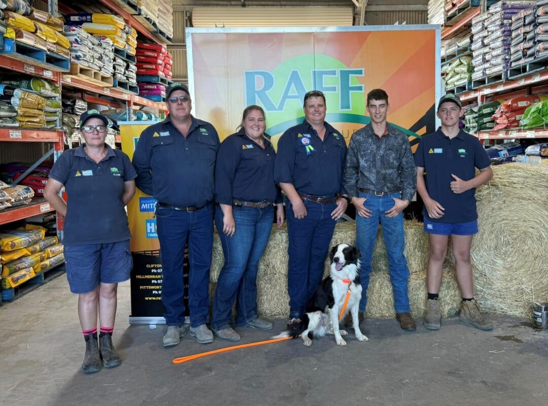 Chief The Muster Dog, with handler Nathan and the RAFF Group team smiling inside the store during a recent RAFF Group Roadshow event.