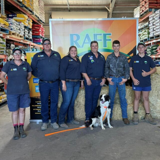 Chief The Muster Dog, with handler Nathan and the RAFF Group team smiling inside the store during a recent RAFF Group Roadshow event.